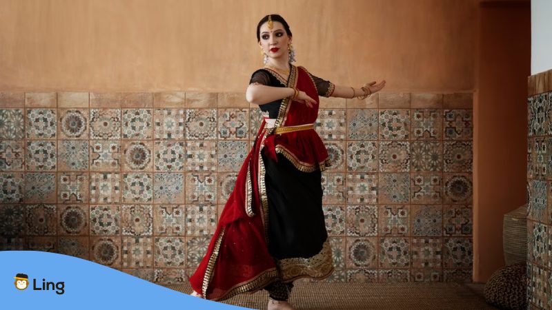 A beautiful Indian woman dancing wearing traditional Punjabi clothes.