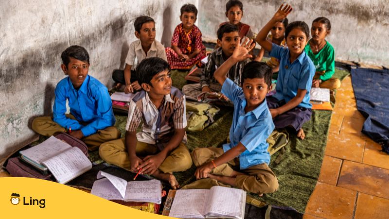 Indische Schüler sitzen auf dem Boden und lernen