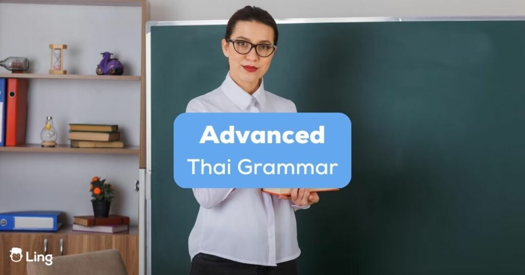 A Thai language teacher with glasses in a classroom behind the advanced Thai grammar texts.