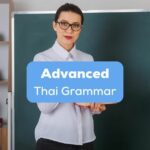 A Thai language teacher with glasses in a classroom behind the advanced Thai grammar texts.
