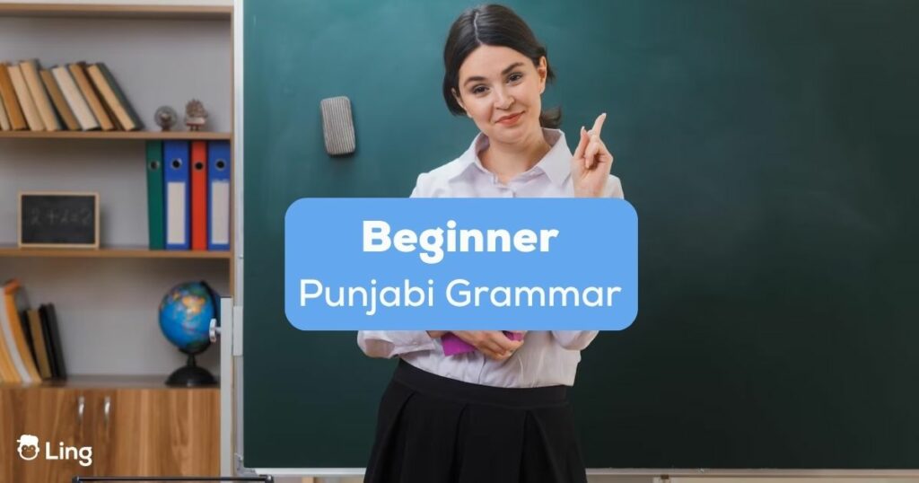 A pretty female teacher inside a classrom behind the beginner Punjabi grammar texts.