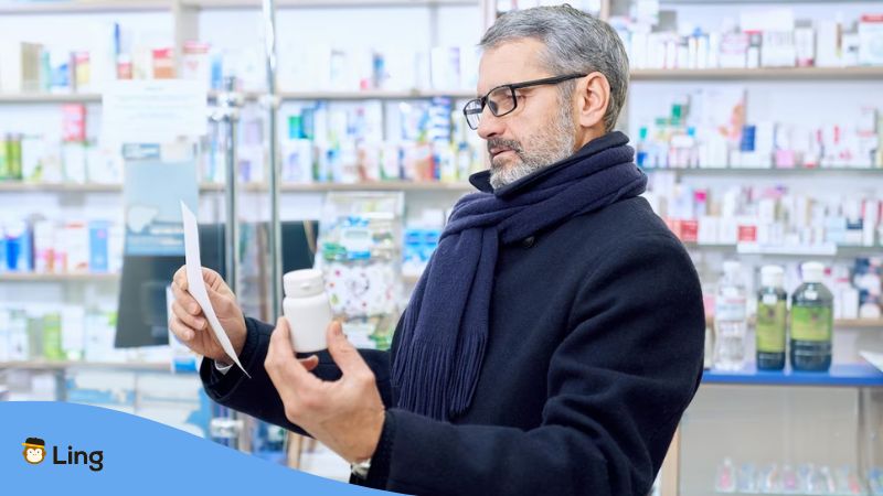 A senior man reading a prescription in inside a pharmacy.