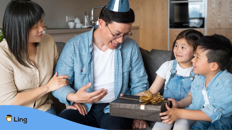 A happy Korean family celebrating Parents' Day with children giving gift to their father on the fourth Sunday of May.