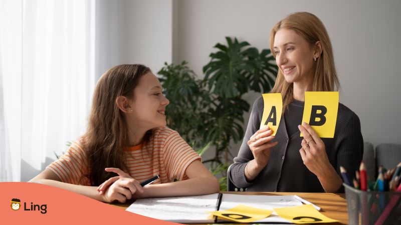 A happy student and her language tutor discussing alphabet.