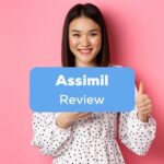 A pretty smiling Asian girl doing a thumbs up sign behind the Assimil review texts.
