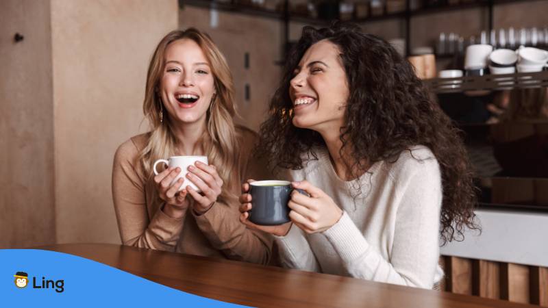 Zwei Frauen sitzen in einem Cafe und trinken Kaffees und unterhalten sich