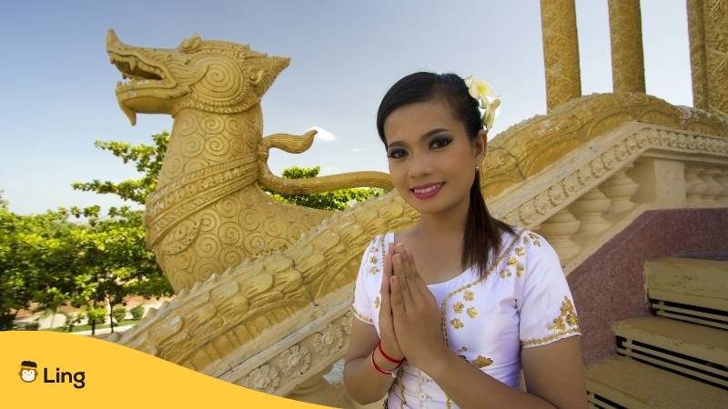 Junge Frau sagt Hallo auf Khmer indem sie das erste Sampeah macht
