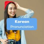 A smiling female Korean with a classic camera behind the Korean pronunciation texts.