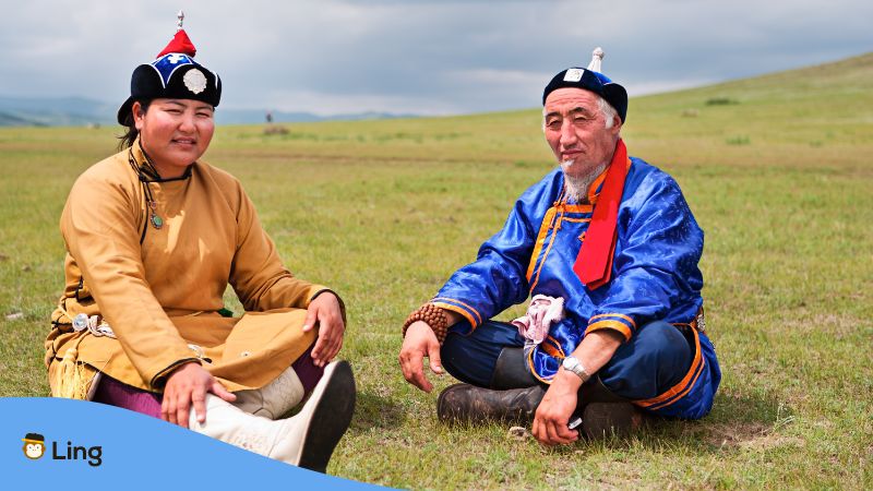 Zwei mongolische Männer sitzen auf einer Wiese
