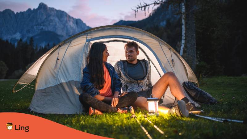 Verliebtes Paar sitzt beim Campen in den slowenischen Bergen im Zelt und geniesst die Romantik der Natur