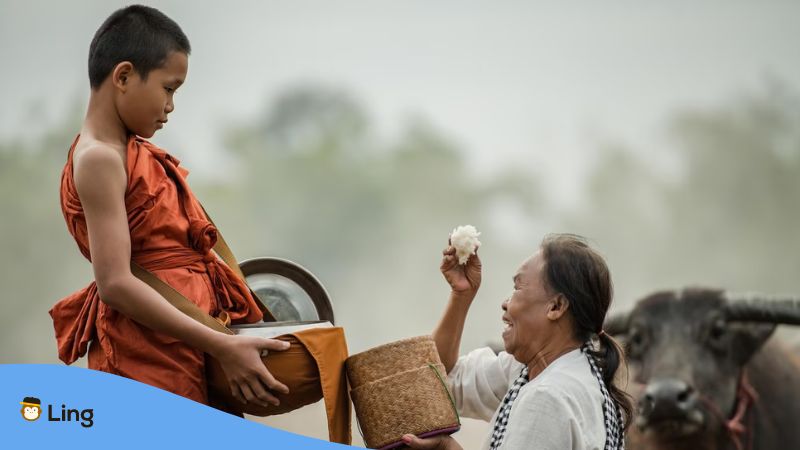 A young monk giving rice to a poor elder in the meadow.