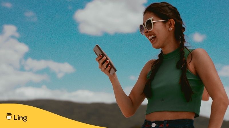 Best Apps For Learning Khmer - A photo of a woman with sunglasses using her phone outdoors