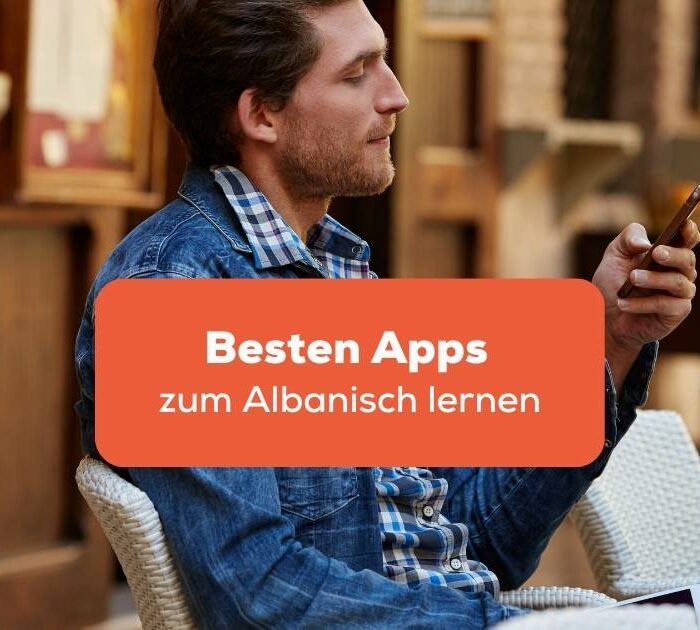 Mann sitzt mit seinem Handy in einem Café und sucht nach den besten Apps zum Albanisch lernen bei Ling