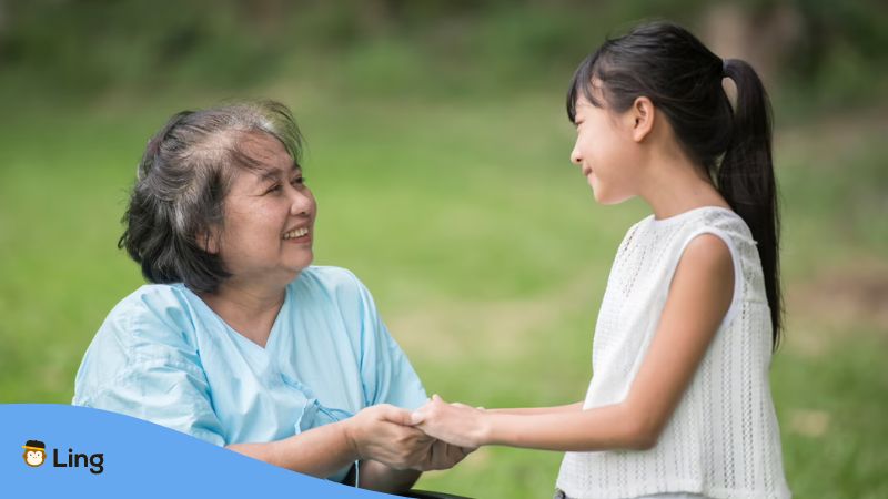 A photo of a you girl talking to an elderly woman using the correct Lao pronouns.