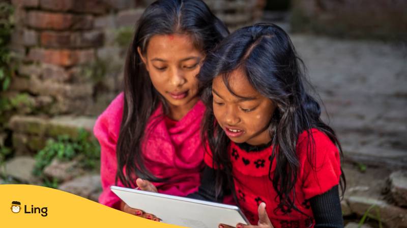 Mädchen lesen gemeinsam in einem Tablet und haben nepalesische Mädchennamen