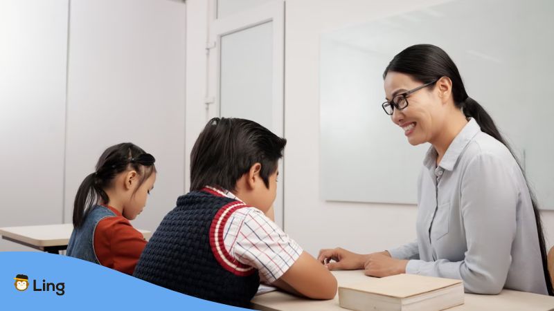 A photo of a female Cantonese language teacher teaching her two students about the relationship of Sino-Tibetan language and Cantonese.