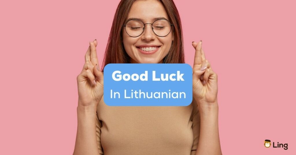 A photo of an excited girl with crossed fingers and closed eyes behind the Good Luck In Lithuanian texts.