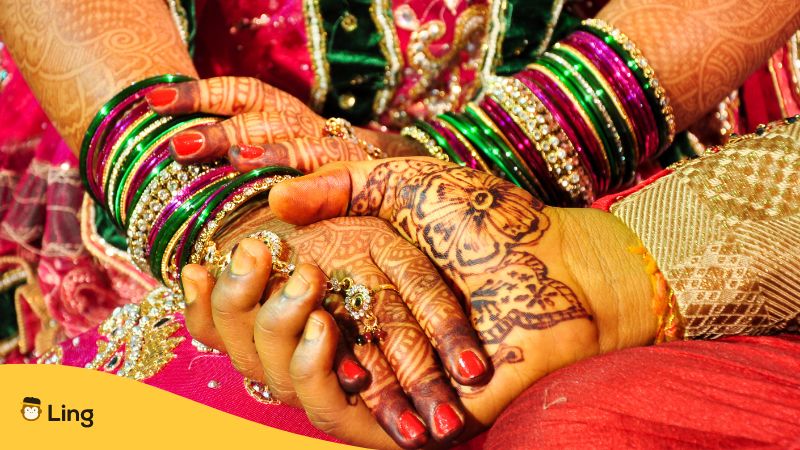 hindu bride and groom wearing traditional accessories and tattoos in arms and hands