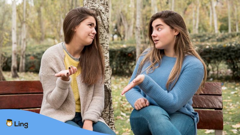 A photo of two girls talking about Bosnian pronouns in a park.