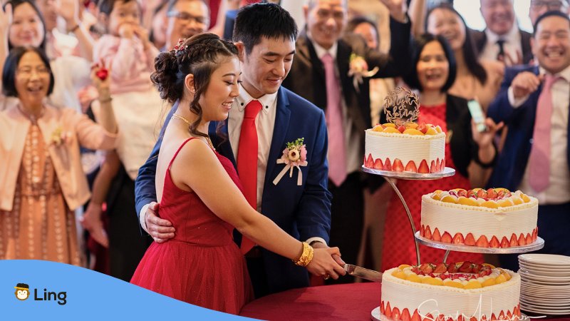 A photo of a couple slicing their wedding cake.