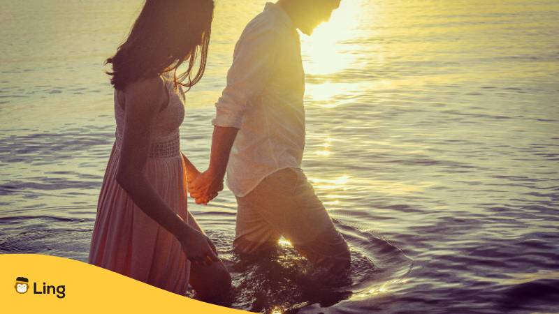 Filipino Paar läuft gemeinsam romantisch durch das Meer und sagt sich süße Komplimente auf Tagalog