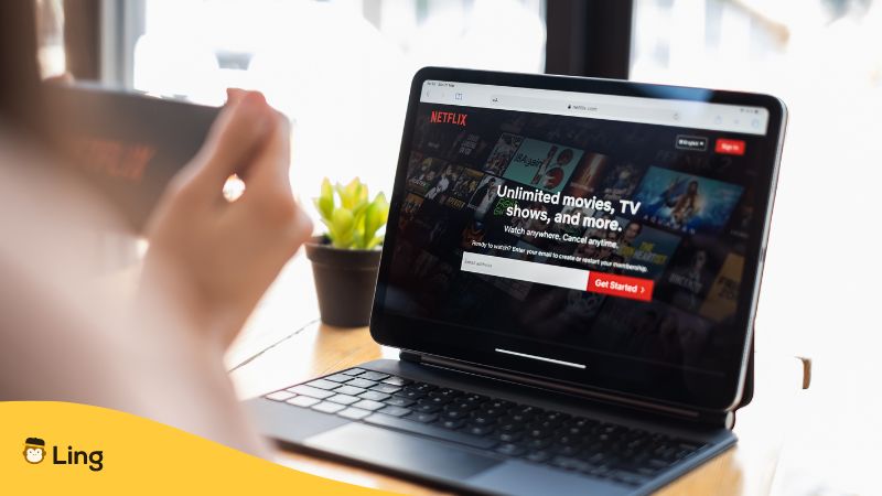 netflix running on a laptop and phone held by a woman