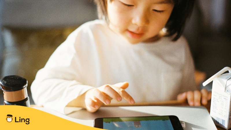 Little girl using phone - Best apps for learning Chinese for kids Ling app