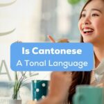 A photo of an Asian female talking to a friend behind the Is Cantonese A Tonal Language texts.