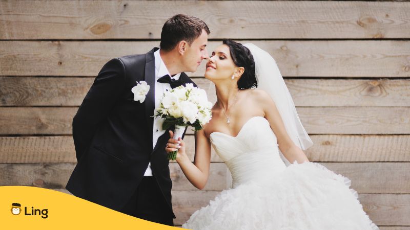 groom about to kiss his bride who is holding a bouquet of white flowers