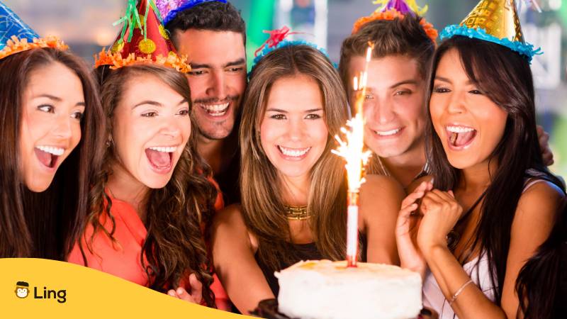 Freunde feiern gemeinsam Geburtstag mit Partyhut und Torte mit Kerze und wünschen Alles Gute zum Geburtstag auf auf Türkisch mit der Ling-App lernen
