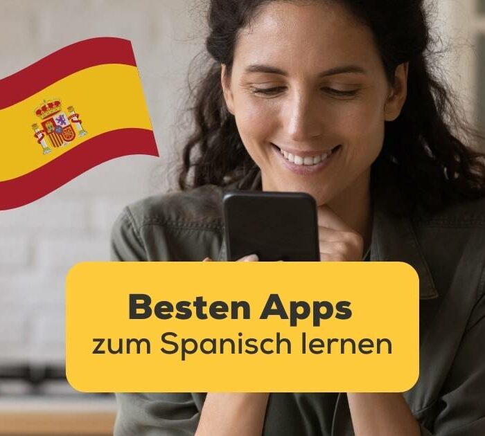 Brünette Frau schaut läcnelnd auf ihr Handy und freut sich mit der Ling-App die bestem Apps zum Spanisch lernen gefunden zu haben