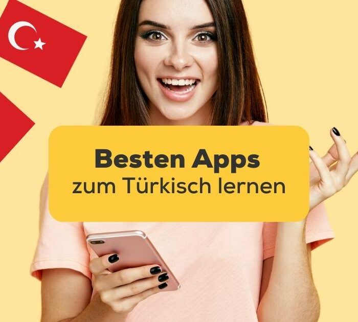 Dunkelhaarige Frau hält Handy in der Hand und recherchiert nach den besten Apps zum Türkisch lernen und hat die Ling-App gefunden