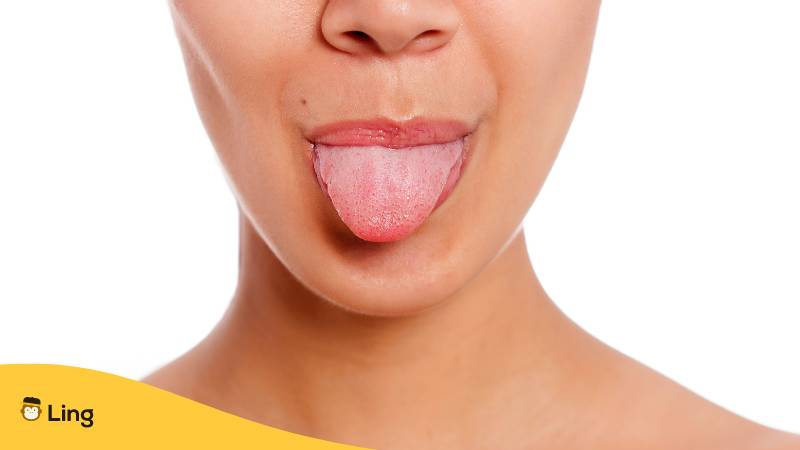 Junge Frau streckt frech die Zunge heraus, weil sie einen Zungenbrecher auf Tagalog gesagt hat