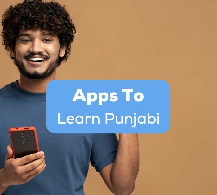 A photo of a smiling Asian male holding a mobile phone behind the Apps To Learn Punjabi texts.