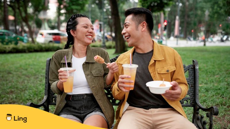 common Tagalog vocabulary - a photo of two friends talking to each other while sitting at a park and eating foods