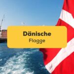 Dänische Flagge wird gehiesst an einem Boot, das durch einen dänischen Hafen fährt