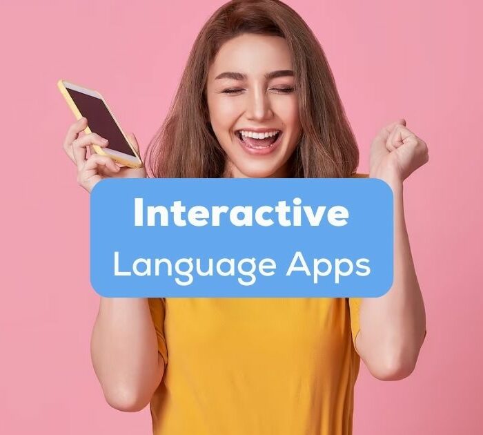 A photo of a happy young woman celebrating with mobile phone isolated over pink background behind the Interactive Language Apps texts.