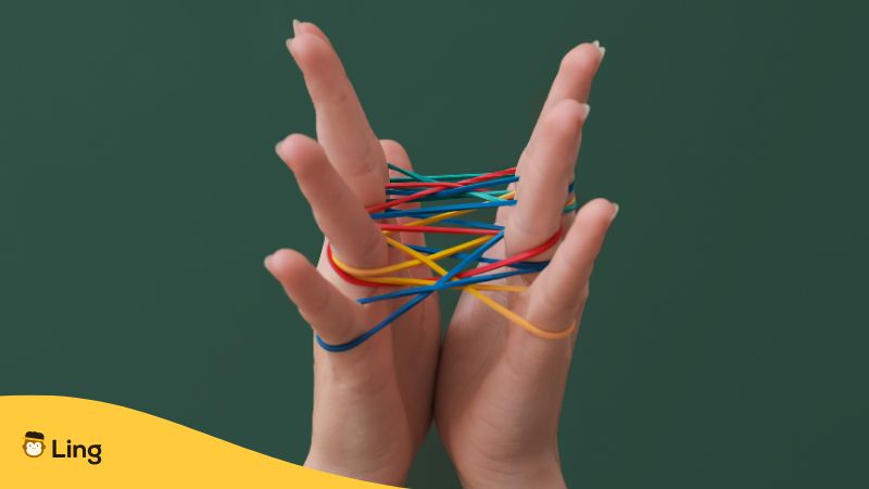 two hands stretching rubber bands to form shapes