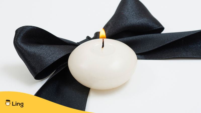 white candle with black ribbon