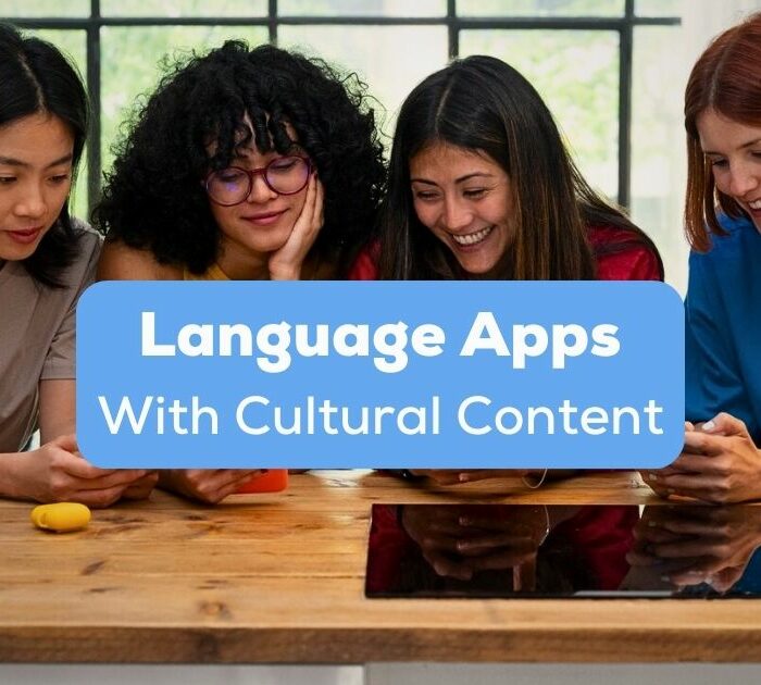 A photo of females from different races happily using their mobile phones behind the Language Apps With Cultural Content texts.
