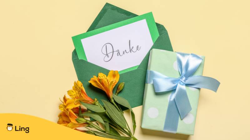 Farbiger Briefumschlag mit Danksagungskarte, einem Geschenk und einen Blumenstrauß, nur eine Art Danke auf Litauisch zu sagen. Erfahre mehr mit der Ling-App.