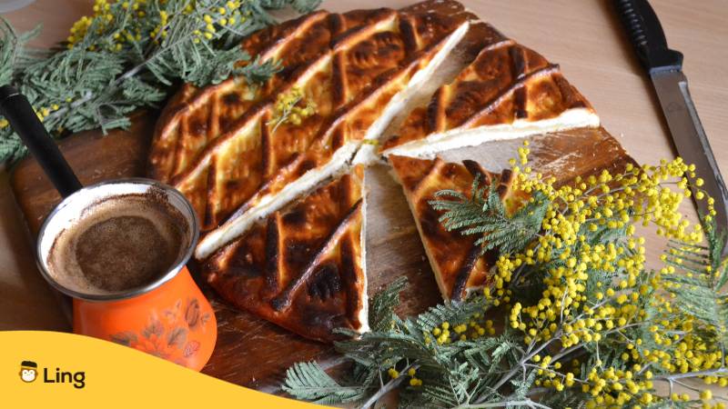 Gata ist ein köstliches armenisches Gebäck mit mehreren Schichten Blätterteig, schön dekorativ mit Zweigen und Kaffee angerichtet. Erfahre mehr über Geschmäcker auf Armenisch mit der Ling-App.