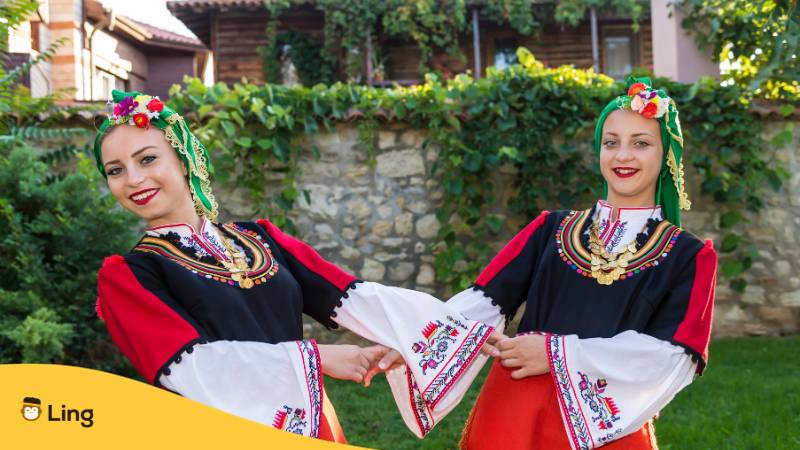 Zwei junge Frauen in traditioneller bulgarischer Tracht sprechen Bulgarisch, eine der gesprochene Sprachen in Bulgarien