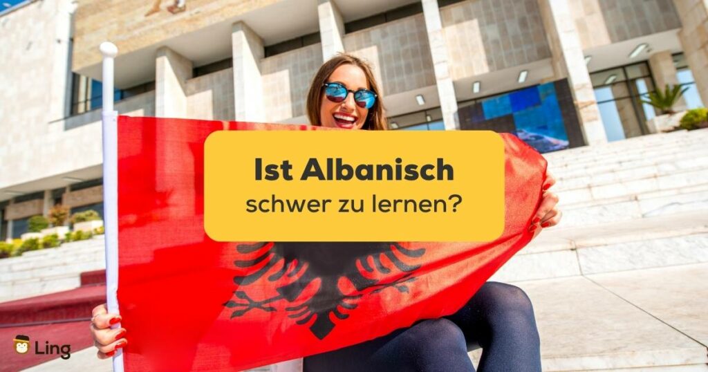 Junge Ling-App nutzerin sitzt mit großer albanischer Flagge vor Gebäude und trägt eine Sonnenbrille und lacht über die Frage Ist Albanisch schwer zu lernen?