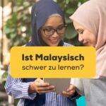 Zwei junge Malaysische Frauen mit Kopftuch diskutieren, ist Malaysisch schwer zu lernen?