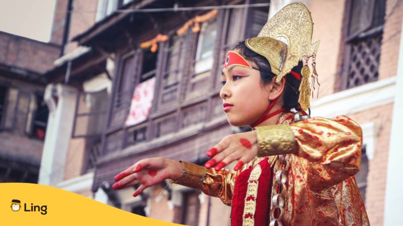 Junge Nepalesin mit traditioneller Kleidung führt traditionellen Tanz auf