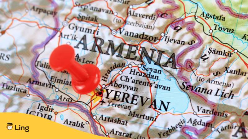 Ausschnitt einer Weltkarte, in der eine Pinnnadel direkt auf Armenien steckt.  