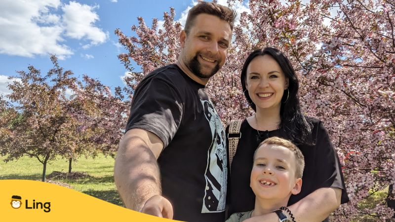 A photo of our user, Kazimira, with her family posing with cherry blossom trees. User story Ling app expat learning lithuanian in Lithuania learn lithuanian
