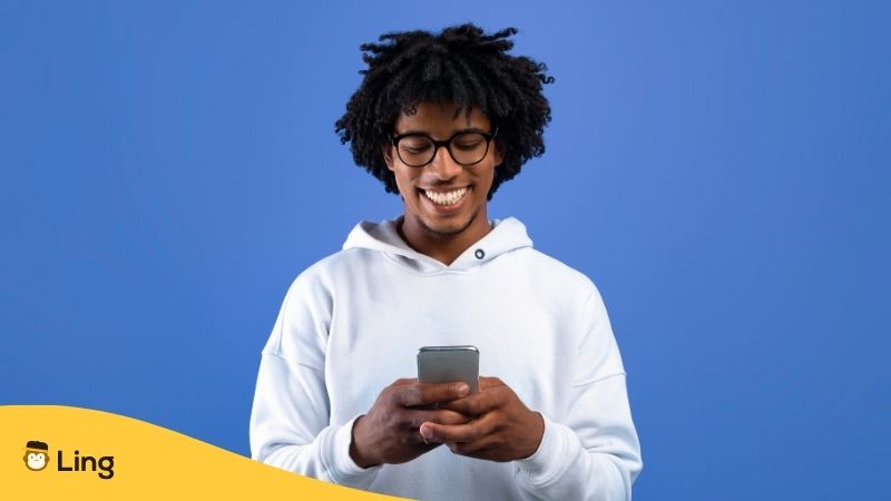 一個男的,用語言應用程序學習語言,露出了開心的笑容