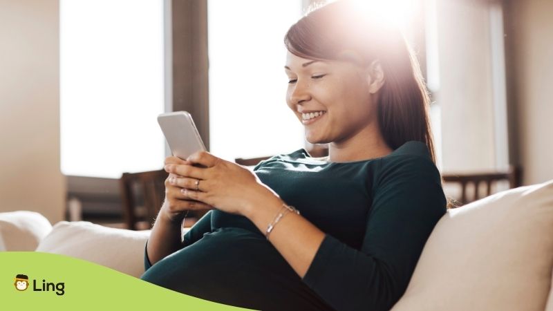 A Pregnant Woman Using An App To Become Fluent On Her Phone